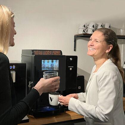 Bettina Stockhausen, Owner Venice Communications GmbH & Co. KG, unterhält sich in der Kaffeeküche bei einer Tasse Kaffee aus dem Kaffeevollautomaten BARISTA Compact