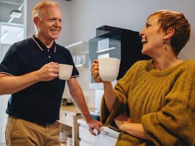 Kaffeepause im Büro Kollegen unterhalten sich lachend bei einer Kaffeepause in der der Küche