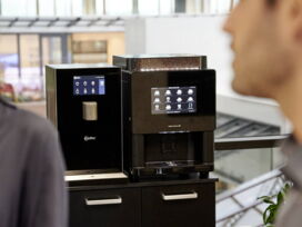 Wasserspender und Kaffeevollautomat auf Unterschrank im Besprechungsraum